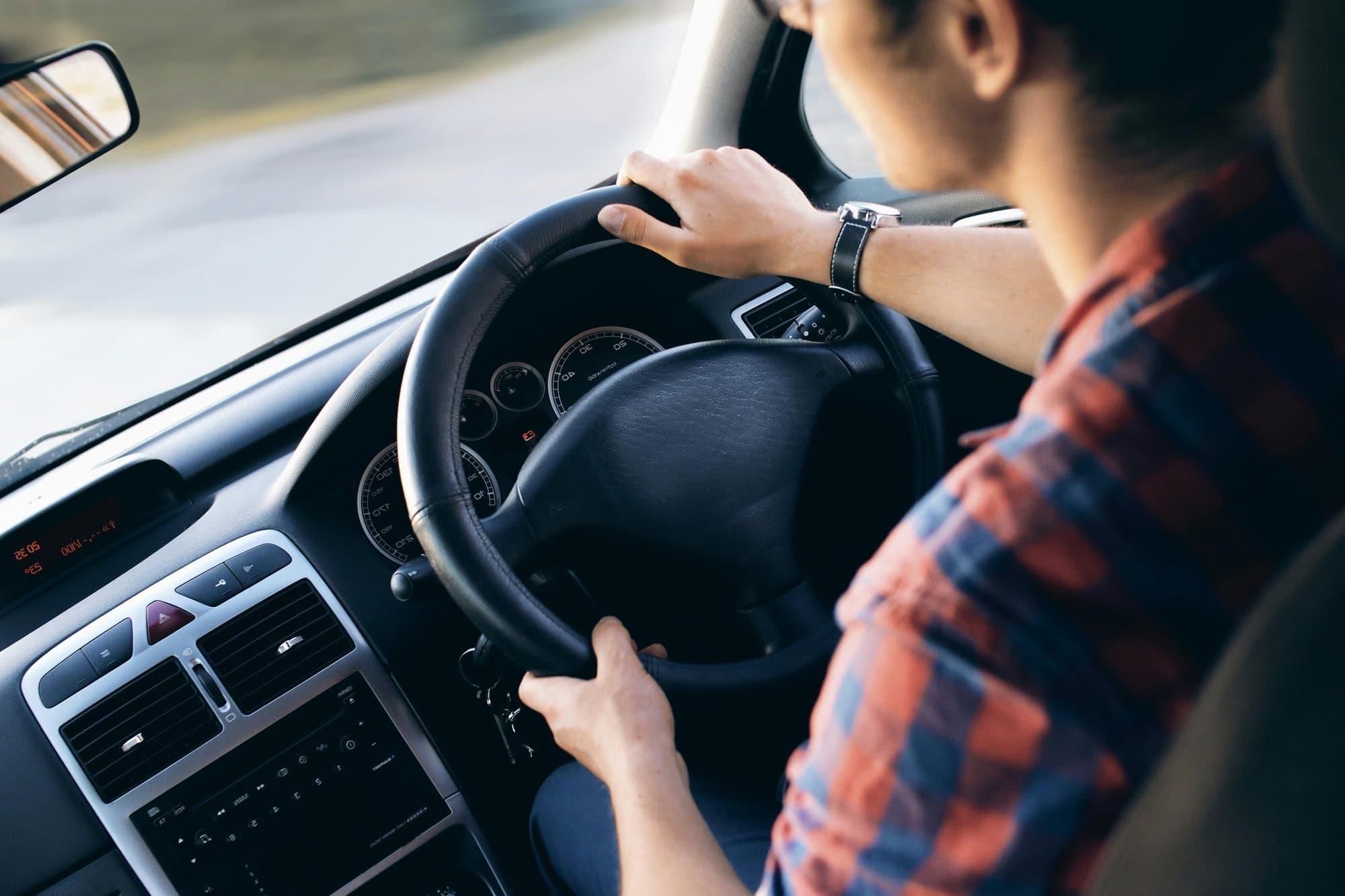 A driver assessed at the wheel of their own vehicle from the instructor's seat